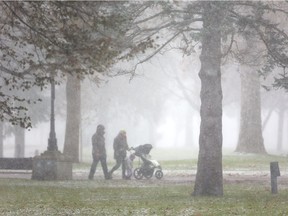 Jamieson Roberts and Nadia Petrasiunas of London walk though a short sudden snow flurry in Victoria Park with their daughter Rowan Roberts, in this file photo. (Free Press files)