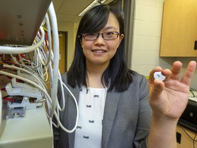 Xia Li, a researcher at Western Universiyt, is testing ultra-thin graphene sheets to help rechargeable batteries, such as the ones in cellphones, last longer. Li tests hundreds of tiny coin batteries in a device that simulates hundreds of charging/discharging cycles.  Mike Hensen/The London Free Press/Postmedia Network