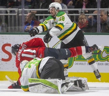 London Knights defenceman Ryan Merkley dumps Egor Afanasyev of the Windsor Spitfires after he tried to dig the puck away from Dylan Myskiw during the first period of their OHL game Friday night at Budweiser Gardens in London. 
Photograph taken on Friday November 29, 2019. 
Mike Hensen/The London Free Press/Postmedia Network