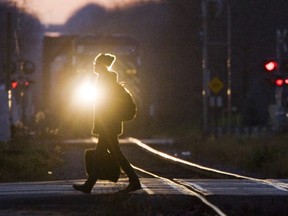 A pedestrian walks across the CP rail tracks on Richmond Street in this Free Press file photo.