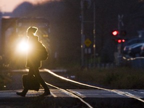 A pedestrian walks across the CP rail tracks on Richmond Street in this Free Press file photo.