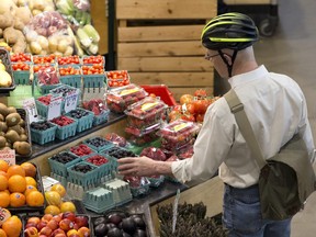 A cyclist takes a pit stop to peruse fresh produce at the Covent Garden Market in London, Ont. on Wednesday May 11, 2016. (File photo)