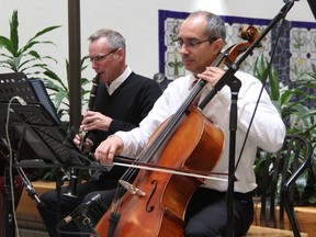 Dr. Chris Watling, left, and Dr. Michael Sanatani play with The Clinic Notes ensemble of cancer doctors for patients and staff at the London Regional Cancer Program at London Health Sciences Centre on Thursday, Dec. 19. The chorus of doctors has been holding Christmas performances at the hospital for the past decade. (Jennifer Bieman/The London Free Press)