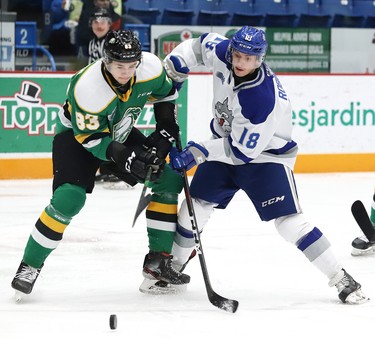 Owen Robinson, right, of the Sudbury Wolves, and Hunter Skinner, of the London Knights, battle for the puck during OHL action at the Sudbury Community Arena in Sudbury, Ont. on Friday December 20, 2019. John Lappa/Sudbury Star/Postmedia Network