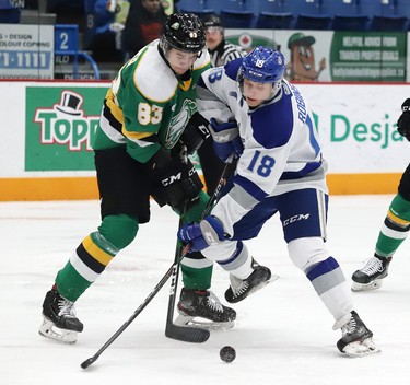 Owen Robinson, right, of the Sudbury Wolves, and Hunter Skinner, of the London Knights, battle for the puck during OHL action at the Sudbury Community Arena in Sudbury, Ont. on Friday December 20, 2019. John Lappa/Sudbury Star/Postmedia Network