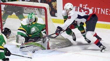 Windsor, Ontario Dec. 15, 2019.  Windsor Spitfires Curtis Douglas, right, tries a wraparound against London Knights goaltender Dylan Myskiw and Avery Winslow, behind,  in the first period of OHL action at WFCU Centre in Windsor Sunday. (NICK BRANCACCIO/Windsor Star)