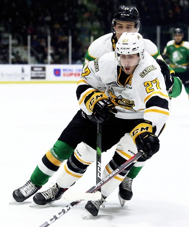 Sarnia Sting's Sean Josling (27) is checked by London Knights' Matvey Guskov (77) in the second period at Progressive Auto Sales Arena in Sarnia, Ont., on Sunday, Dec. 29, 2019. (Mark Malone/Postmedia Network)