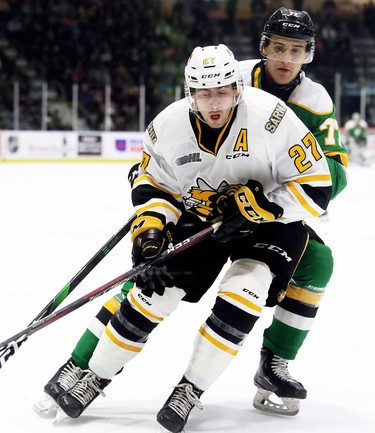 Sarnia Sting's Sean Josling (27) is checked by London Knights' Matvey Guskov (77) in the second period at Progressive Auto Sales Arena in Sarnia, Ont., on Sunday, Dec. 29, 2019. (Mark Malone/Postmedia Network)