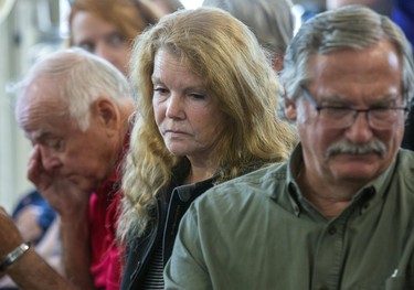 Stan Millard, Muriel Burnley and her husband Dan Silcox (left to right) listen to commissioner Eileen Gillese speak at the release in Woodstock of the final report of a two-year probe into the long-term care system sparked by the murders of eight people by former nurse, Elizabeth Wettlaufer. Millard is the son of Gladys Millard and Dan Silcox is the son of James Silcox, two of of Wettlaufer's victims.  (Derek Ruttan/The London Free Press)