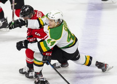 Owen Sound Attack defenceman Nolan Seed checks  London Knight Jonathan Gruden in the first period of their game at Budweiser Gardens in London, Ont. on Saturday December 7, 2019. Derek Ruttan/The London Free Press/Postmedia Network