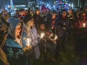 People gathered at the London Woman's Monument in Victoria Park to pay tribute to 14 women murdered at Ecole Polytechnique  on the 30th anniversary of the Montreal Massacre. (Derek Ruttan/The London Free Press)