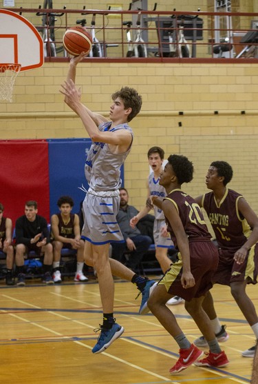 Brendan Mills of Oakridge shoots while covered by Banting's Ali Salah during their TVRA Central senior boys basketball game at Oakridge secondary school in London on Thursday. Banting won the game 53-41. (Derek Ruttan/The London Free Press)