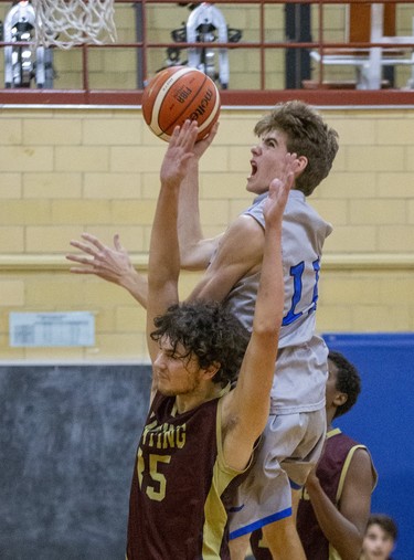 Brendan Mills of Oakridge jumps and shoots above Banting's J.J. DeGrace during their TVRA Central senior boys basketball game at Oakridge secondary school in London on Thursday. Banting won the game 53-41. (Derek Ruttan/The London Free Press)