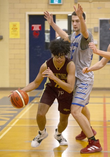 Banting's Kyle Thomas dribbles past Oakridge's Georgije Pavlovic during their TVRA Central senior boys basketball game at Oakridge secondary school in London on Thursday. Banting won the game 53-41. (Derek Ruttan/The London Free Press)