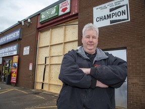 Rick McMullin, owner of Ricky Ratchets Auto Repair, has had to erect a temporary wood door after a truck recently crashed through the bay door in London. Derek Ruttan/The London Free Press/Postmedia Network