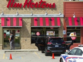 Police surround a Tim Hortons location on Dundas Street at Industrial Road after a man was shot and taken to hospital with injuries considered life threatening on Wednesday Sept. 12, 2018. (Mike Hensen/The London Free Press)
