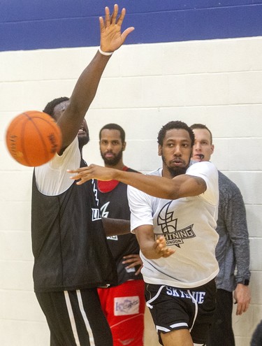 Lightning's Marcus Capers passes around Randy Phillips under the watchful eye of new Lightning head coach Doug Plum. Plum says this week is going to be a "grind for the guys," as they get up to speed during the first week of the London Lightning training camp  in London.  (Mike Hensen/The London Free Press)