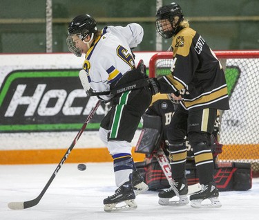 Tyler Raymond of the St. Joe's Rams tries to deflect a shot past goalie Ethan Peixoto of the Holy Cross Centurions while being checked by Nolan Griffiths of the Centurions during their game on Wednesday at Joe Thornton Arena in St. Thomas. (Mike Hensen/The London Free Press)