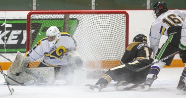 Owen Boersma of the Holy Cross Centurions gets hauled down by Ben Novacich of the St. Joe's Rams in front of Rams goalie Maclane Stringle during their game on Wednesday at Joe Thornton Arena in St. Thomas. (Mike Hensen/The London Free Press)