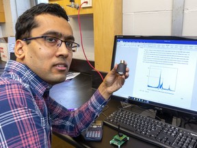 Ayan Sadhu, an assistant professor of Civil and Environmental engineering at Western University holds an accelerometer that he uses to study vibrations on structures like bridges and dams. (Mike Hensen/The London Free Press)
