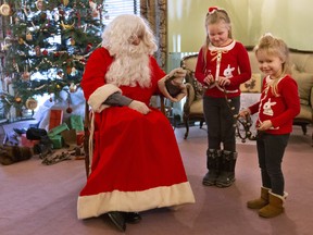 Joe O'Neil in the role of Father Christmas rings a set of bells with Zofia Reed, 7, and Gabriela Reed, 3, on Sunday, December 8, 2019 at Eldon House, where they are celebrating a Victorian Christmas until Jan. 1. (Mike Hensen/The London Free Press)