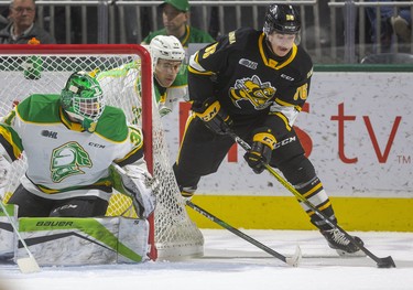 Nolan Burke of the Sting comes from behind the net being trailed by Matvey Guskov of the Knights with Dylan Myskiw in net in the first period of their game at Budweiser Gardens in London, Ont.  Photograph taken on Friday December 13, 2019.  Mike Hensen/The London Free Press/Postmedia Network