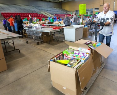 Backstage at the Salvation Army's Christmas hamper giveaway at the Western Fair Agriplex Dale Matheson moves some heavy boxes crammed with toys for sorting. Photograph taken on Monday December 16, 2019.  Mike Hensen/The London Free Press/Postmedia Network