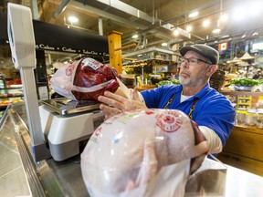 Chris Lyons of Chris' Country Cuts in Covent Garden Markets weighs a shipment of 13- to 17-pound turkeys before sale Wednesday. A skin ailment among some turkeys weighing more than 18 pound has left a gap in the market. (Mike Hensen/The London Free Press)