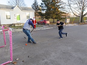 It was Hockey Day on Napier Street in London with the neighbourhood Santa (Tom Doyle) looking on as Nate Carter tries to block a shot from 11-year-old Desmond Rawson on Monday afternoon December 23, 2019.  Mike Hensen/The London Free Press