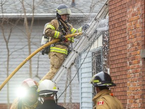 A London firefighter hoses down a rear apartment after they stripped off the cladding at 71 Adelaide Street north in London, Ont. on Thursday December 26, 2019. A fire was reported on Boxing Day morning in the rear of the building and all the residents were able to leave the building on their own. There were no injuries reported. Mike Hensen/The London Free Press/Postmedia Network