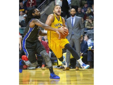 Garrett Williamson of the Lightning goes up past Nigel Tygther of the Kitchener-Waterloo Titans during the Lightning's home opener game at Budweiser Gardens in London, Ont. on Friday Dec. 27, 2019.  (Mike Hensen/The London Free Press)