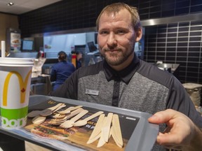 Travis Kosmala, the general manager of the McDonalds on Wonderland Road near Southdale shows off their paper lids, paper straws and non-plastic cutlery that is being tried in their location in London, Ont.  McDonalds is testing their low plastic model in two locations. (Mike Hensen/The London Free Press)