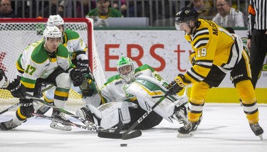 London Knights goalie Brett Brochu sprawls way out of position and is backed up by teammates Ryan Merkley and Nathan Dunkley as Sarnia's Ryan McGregor looks for a way to get the puck across to a teammate. After a mad scramble, including a goal-saving skate by Merkley, the Knights got out of the period unscathed during their New Year's Eve game Tuesday afternoon at Budweiser Gardens in London. Mike Hensen/The London Free Press/Postmedia Network