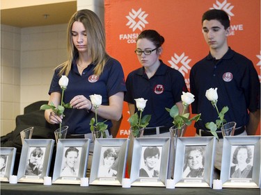 Fanshawe College student  Montanna Blair places a white rose in a vase during a ceremony to remember the victims of the Montreal Massacre in London, Ont. on Friday December 4, 2015.  (Derek Ruttan/The London Free Press)