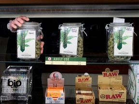 An employee holds a jar of marijuana on sale at the Greenstone Provisions after it became legal in the state to sell recreational marijuana to customers over 21 years old in Ann Arbor, Michigan, U.S. December 3, 2019. Picture taken December 3, 2019.