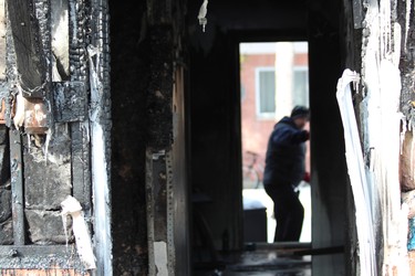 A police officer closes the back door to a townhouse at 99 Kimberley Ave., where a fire damaged three units in the complex on Tuesday night. A London man, 28, is charged with arson with disregard for human life. (DALE CARRUTHERS, The London Free Press)