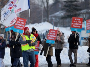 Ian Morton, an Avon Maitland District school board elementary school teacher and Elementary Teachers' Federation of Ontario (EFTO) executive, waves a flag in front of Perth-Wellington MPP Randy Pettapiece's office during the one-day EFTO strike on Thursday January 23, 2020 in Stratford. Terry Bridge/Stratford Beacon Herald/Postmedia Network