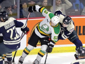 London Knight Markus Phillips holds off Windsor Spitfire Curtis Douglas in OHL action from Windsor's WFCU Centre Thursday. (Nick Brancaccio/Postmedia News)