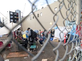 A group of homeless people living in the Downtown Eastside gather around a fire in a tent city that has been erected on West Hastings in Vancouver, B.C.
