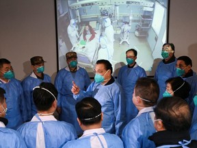 Chinese Premier Li Keqiang wearing a mask and protective suit speaks to medical workers as he visits the Jinyintan hospital where the patients of the new coronavirus are being treated following the outbreak, in Wuhan, Hubei province, China January 27, 2020. (cnsphoto via REUTERS)