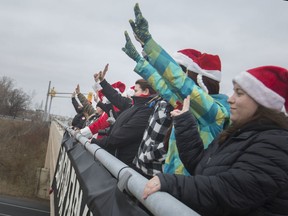 Protesters seeking a ban on fur farming line the Central Avenue overpass at E.C. Row Expressway in Windsor on Thursday, Dec. 26, 2019.