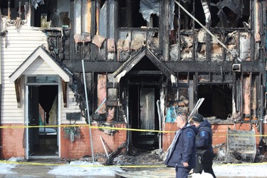 Police survey the scene at 99 Kimberley Ave., where a fire damaged three townhouses on Tuesday night. A London man, 28, is charged with arson with disregard for human life. (DALE CARRUTHERS, The London Free Press)