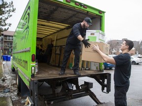 Kevin Lorimer (right) hands boxes to fellow SS&D The Movers employee Ryan Chedore as the two load the contents of an apartment into a moving truck. (Derek Ruttan/The London Free Press)