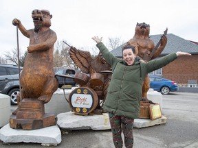 Jenny de Miranda is the program co-ordinator of the Hamilton Road BIA in London. Hamilton Road is known for its dozens of tree-trunk carvings like the one behind her, titled Stihl Tree O Band. (Derek Ruttan/The London Free Press)