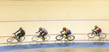 Cyclists ride through one of the Forest City Velodrome's 55-degree corners in London on Sunday. Derek Ruttan/The London Free Press/Postmedia Network