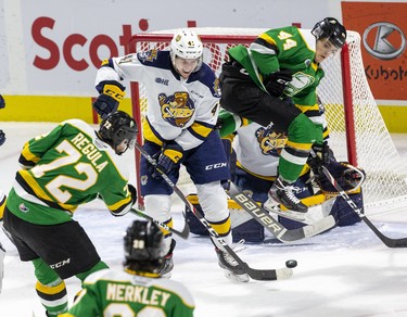 London Knight Alec Regula shoots through teammate  Jonathan Gruden and  Erie Otter Kurtis Henry during the third period of their game at Budweiser Gardens in London, Ont. on Sunday January 19, 2020. Otters goalie Daniel Murphy was able to stop the shot. Derek Ruttan/The London Free Press/Postmedia Network