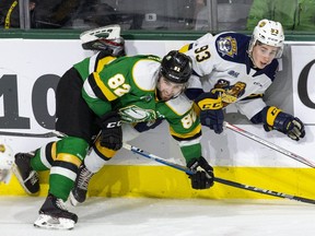 Emmett Sproule of the Erie Otters is pinned against the boards by Jason Willms of the London Knights during the third period of their game at Budweiser Gardens in London, on Sunday January 19, 2020. (Derek Ruttan/The London Free Press)