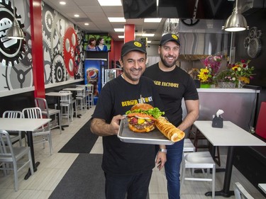 Co-owners Alaa Senjab, left, and Medo Ali present the Compressor, a triple cheeseburger with a side of tornado fries at the new Burger Factory in London. They opened Friday and are holding a grand opening Saturday that includes taking meals to the homeless. (Derek Ruttan/The London Free Press)