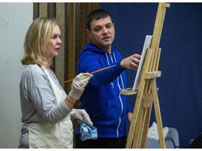 Instructor Paul Abeleira advises Jan Collins during an oil painting class at the TAP Centre For Creativity in London on Thursday January 23, 2020. (Derek Ruttan/The London Free Press)