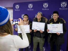 Samantha Munro of Western student experiences photographs Austin Huang, Ivan Ye and Johnny Lum of Western as they hold their thought bubbles at Bell Let's Talk Wednesday January 31, 2018 at the wellness education centre. The student centre was handing out 750 bright blue Bell toques to students who posed with their thoughts of mental health as a show of support to those with mental health issues and to end the stigma associated with mental health. (Mike Hensen/The London Free Press)